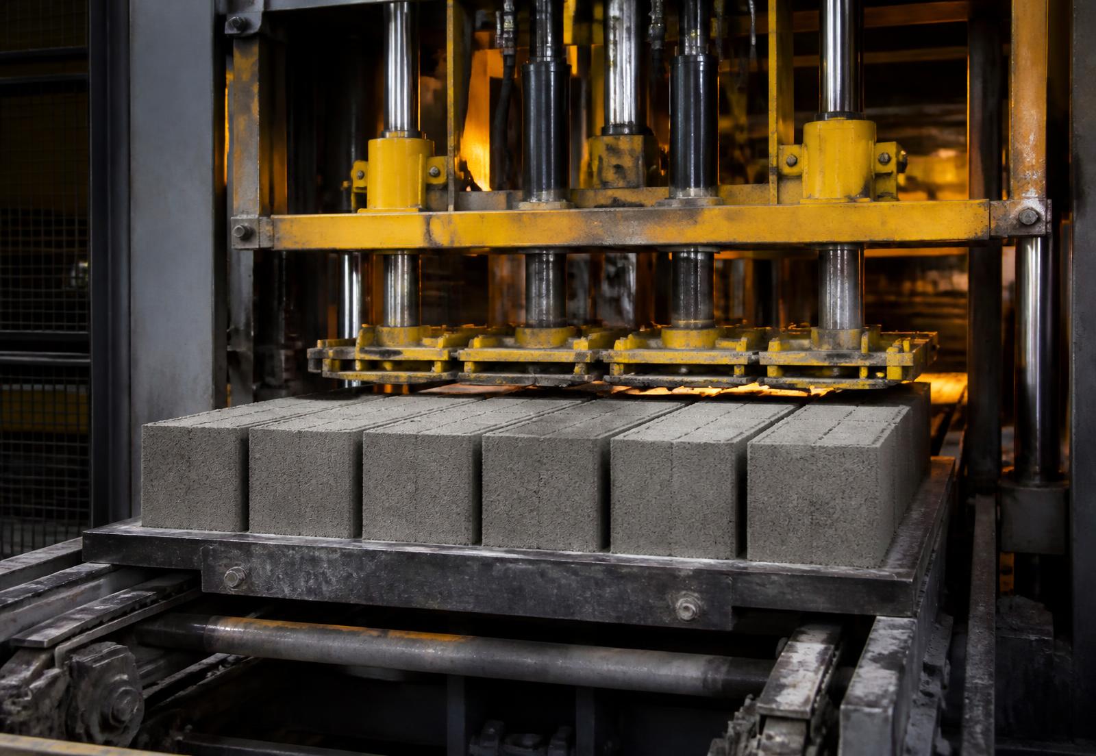 Automated hydraulic block machine forming concrete blocks on a steel pallet